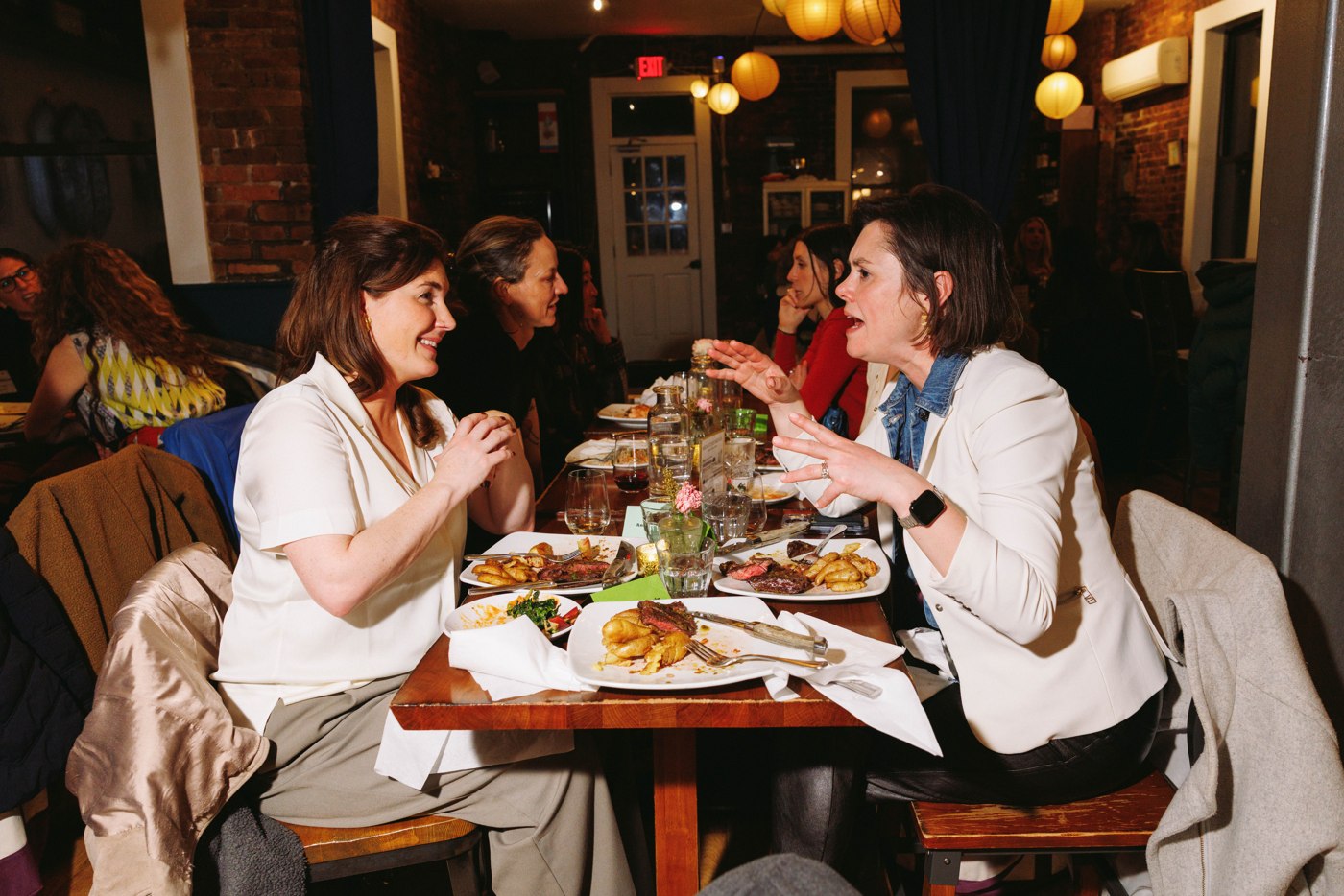 Women connecting over dinner at the WELL Summit