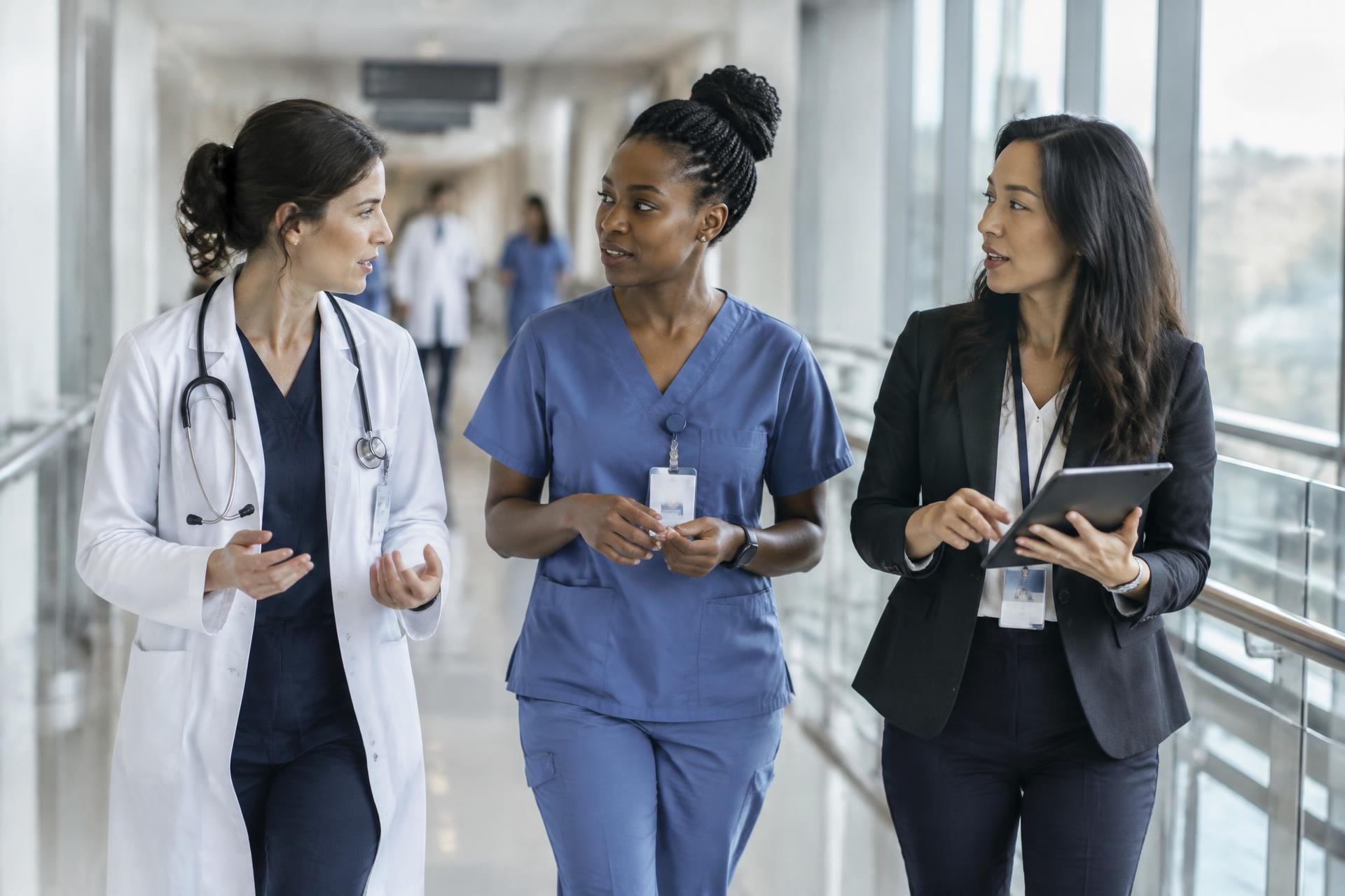 Women clinicians and scientists walking and talking in a hospital corridor